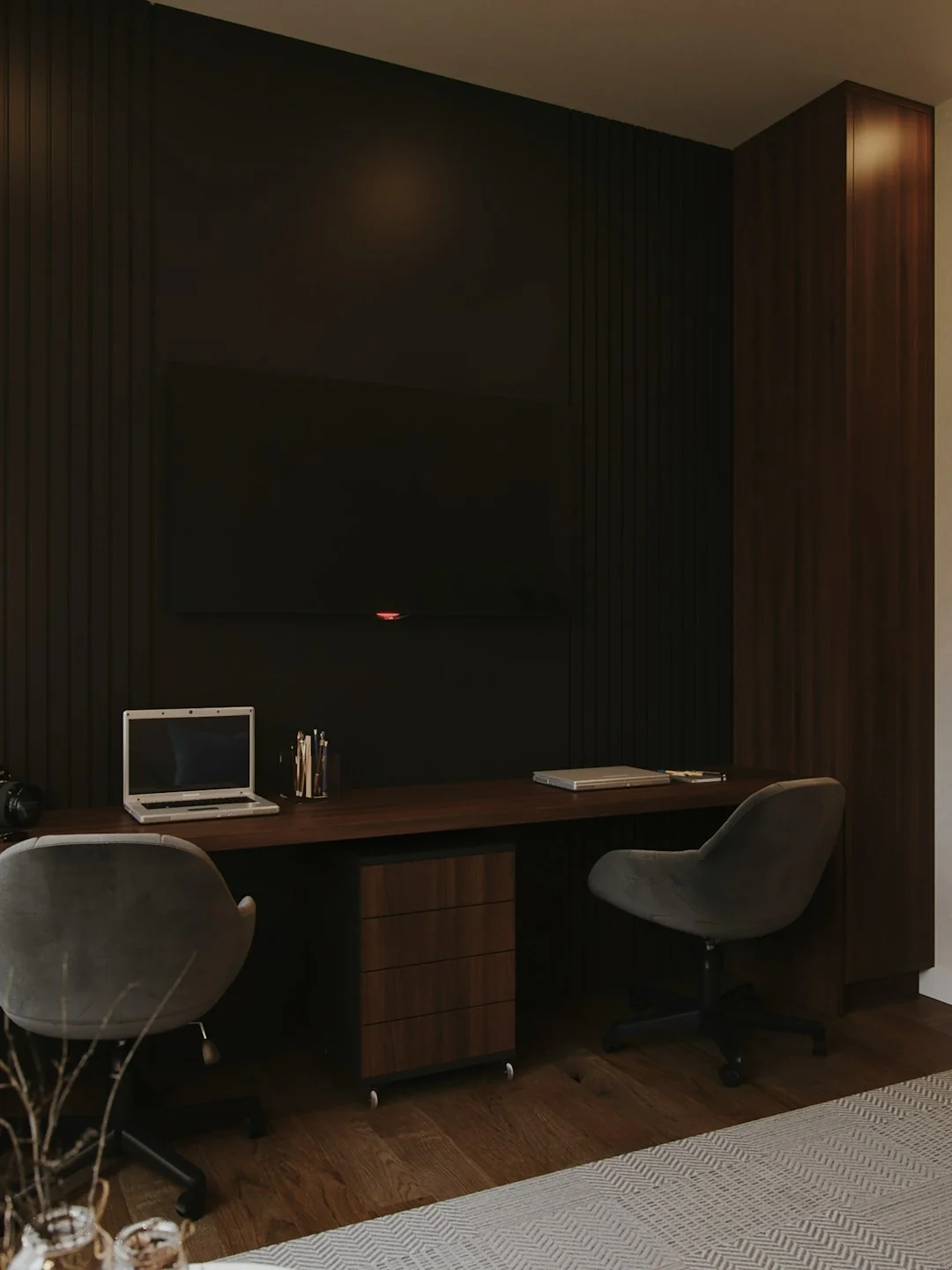 A sleek workspace with a laptop and monitors showing design software.
